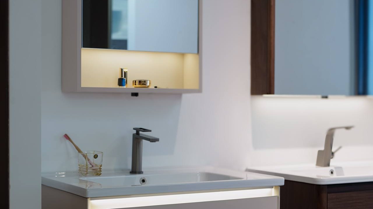A white wall-mounted vanity with a tall basin tap