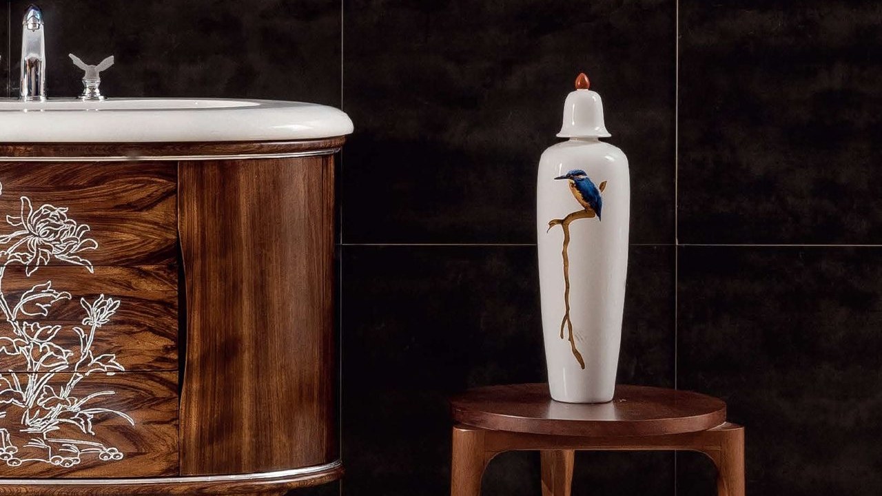 An ornate carved wood vanity beside a decorative vase
