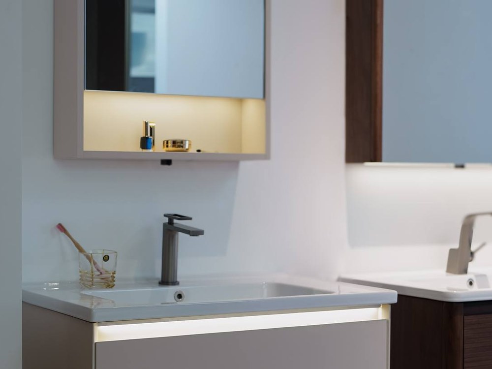 A white wall-mounted vanity with a tall basin tap