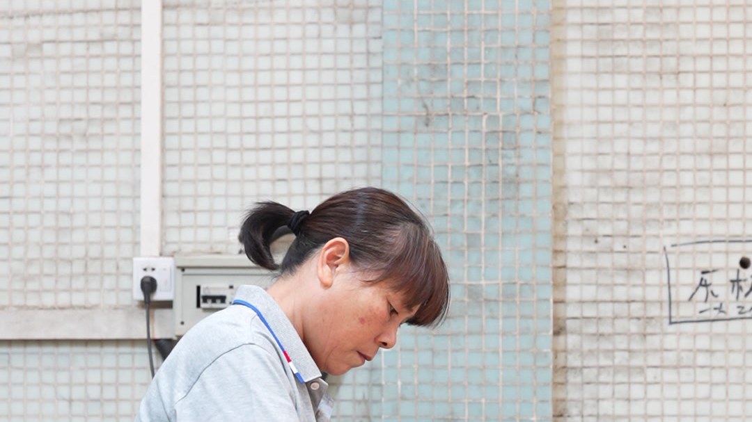 A worker pressing veneer onto a panel by hand
