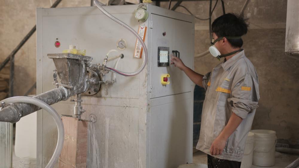 Worker operating a casting process for bathroom bathware