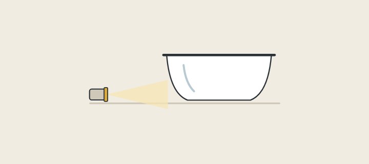Illustration of a low lamp shining along the side of a freestanding bathtub
