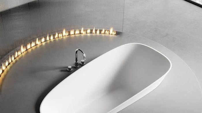 An oval bathtub integrated into a stone deck