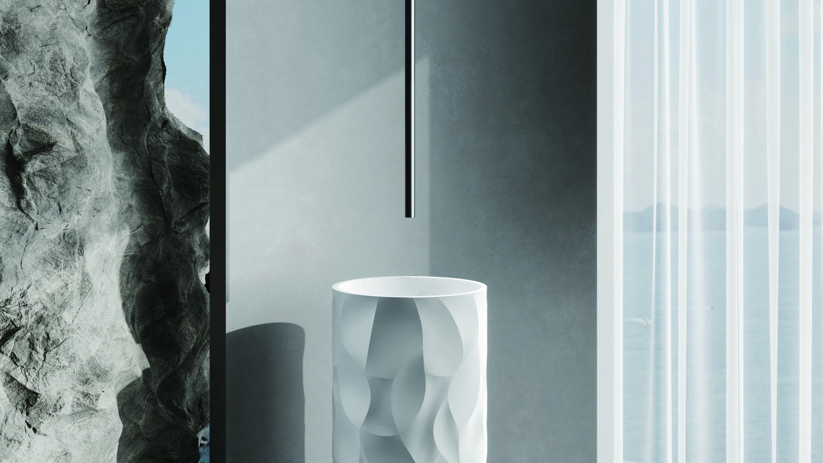 A textured white freestanding basin against a stone backdrop