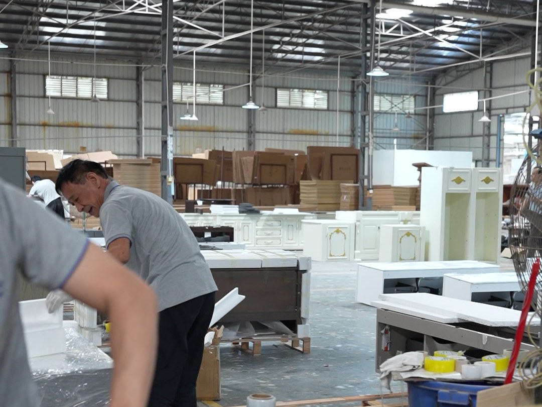 A worker checking a packed carton on a bench in the warehouse