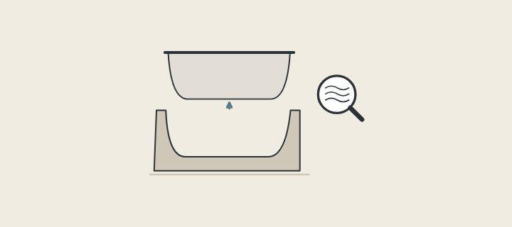 Illustration of an unfinished tub shell lifted out of its mold beside a magnifier