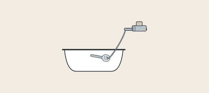 Illustration: a hand shower lying in a filled tub with its hose rising to a wall supply with a vacuum-breaker fitting