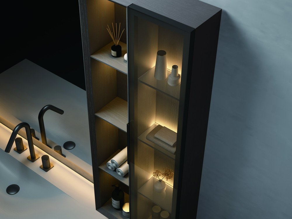 A dark vanity cabinet with open shelves and a wall-mounted tap