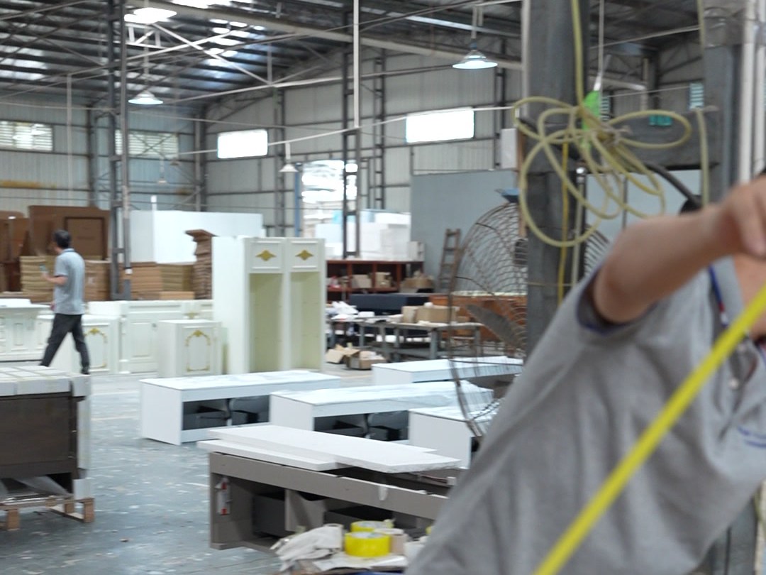 A worker holding a tape measure across a packed carton