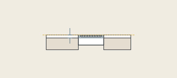 Illustration: a channel drain in section with its grate frame level with the finished tile surface and a bracket marking the tile thickness