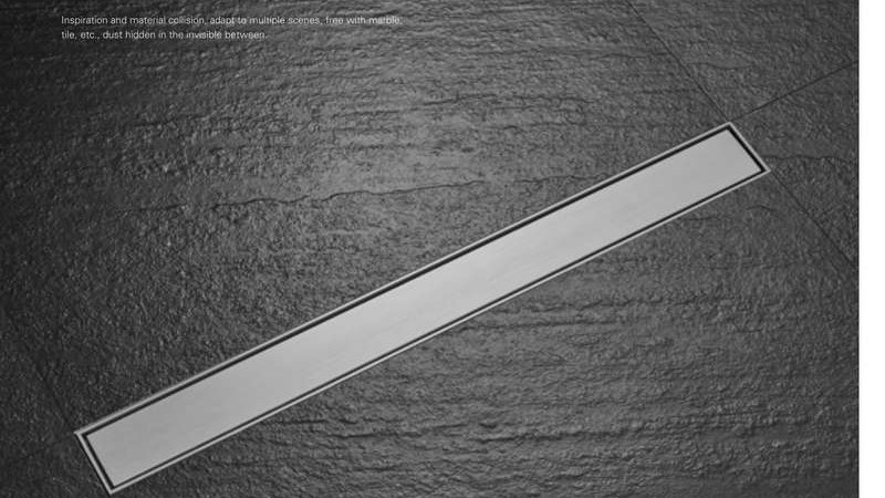 A linear floor drain shown at an angle on dark stone