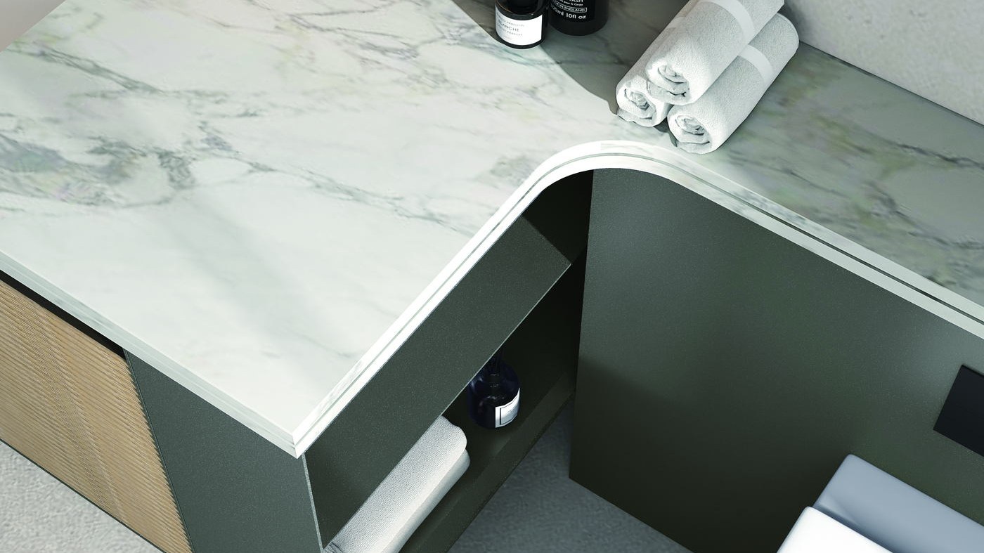 A marble countertop with bottles and towels beside a basin