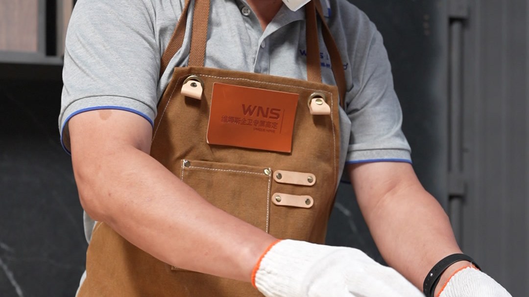 Gloved hands stirring a finish mixture beside a basin