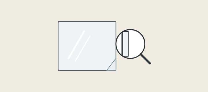 Illustration: a mirror with protective film at one corner and a magnifier over a mirror edge