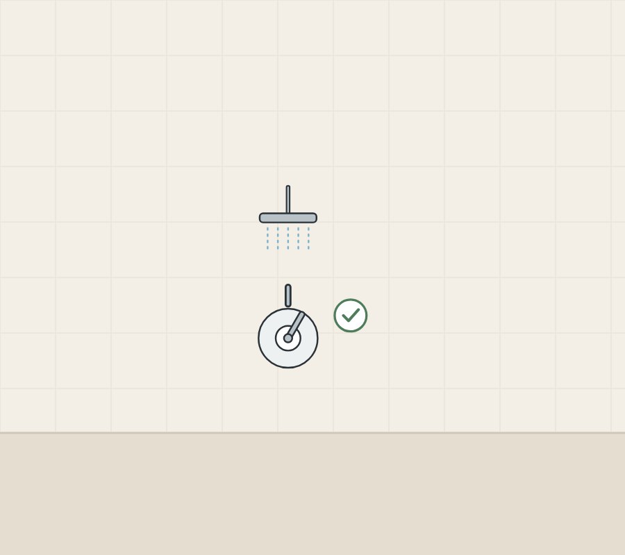 Illustration of a shower head piped to a control plate, with a tick