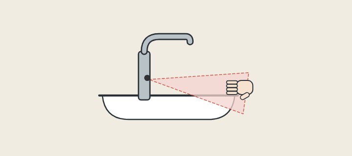 Illustration: a sensor faucet over a basin with its detection zone drawn as a cone and a hand entering it