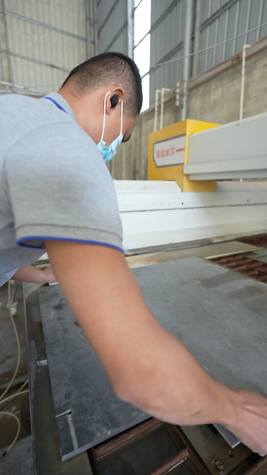 Operator preparing a vanity top at a waterjet cutting station