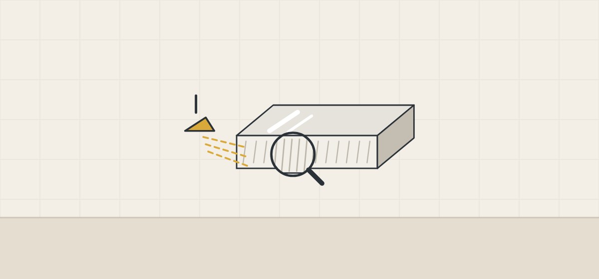 Illustration of a top with a glossy face and a duller cut edge under a magnifier, lit by a lamp at a low angle