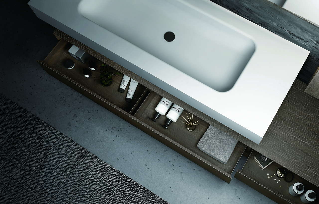 Integrated solid surface basin top shown above a dark wood vanity cabinet with hardware samples