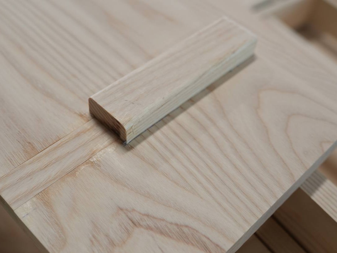 A pale wood panel with an inset strip, shown as a material sample
