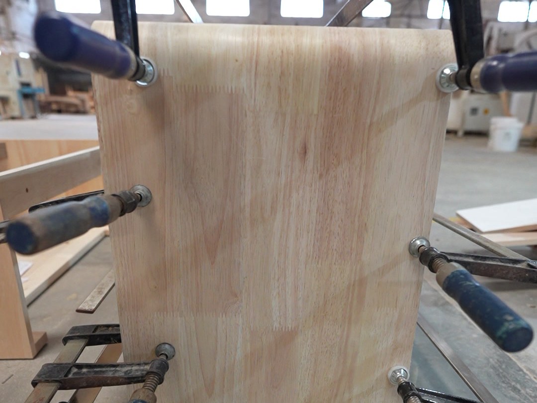 Clamps holding a laminated curved panel while the glue sets