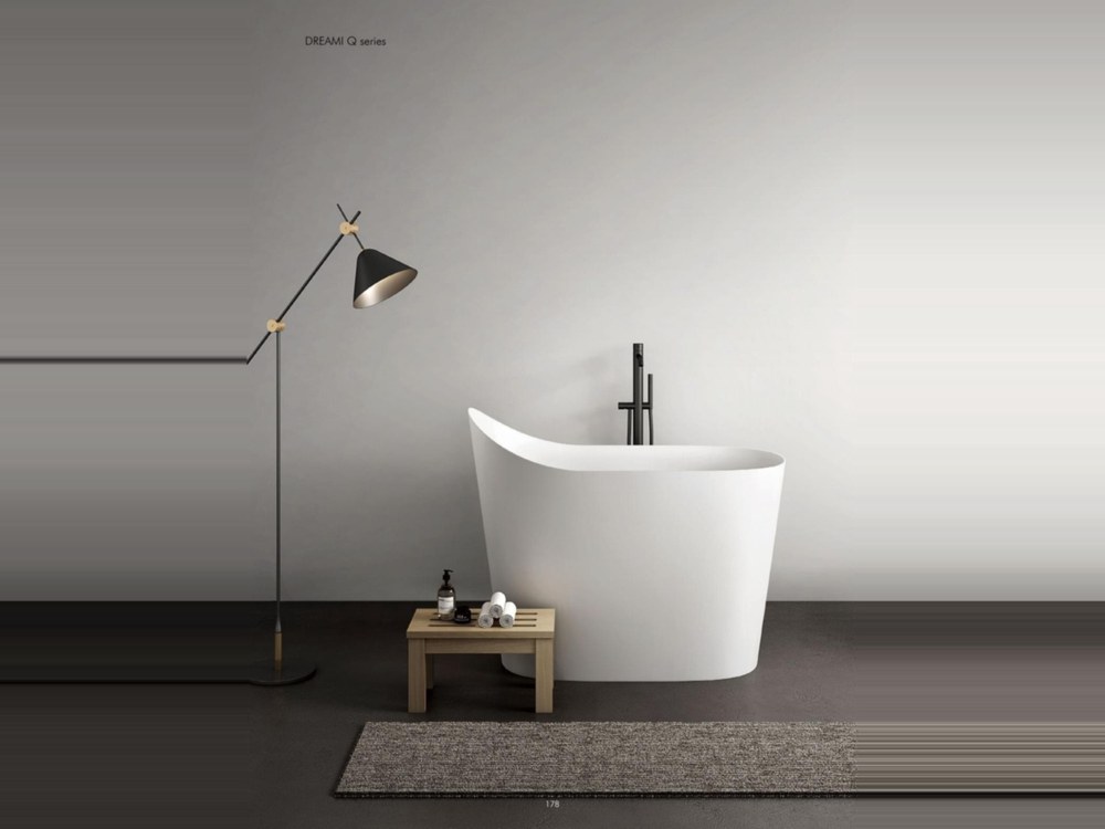 Sculpted freestanding solid surface bathtub with floor-mounted mixer