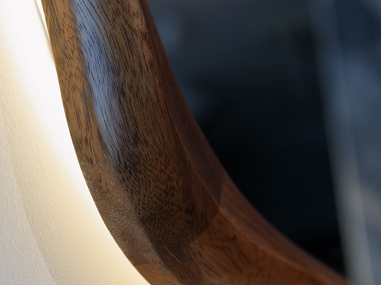 Hand-shaped walnut mirror frame with concealed lighting