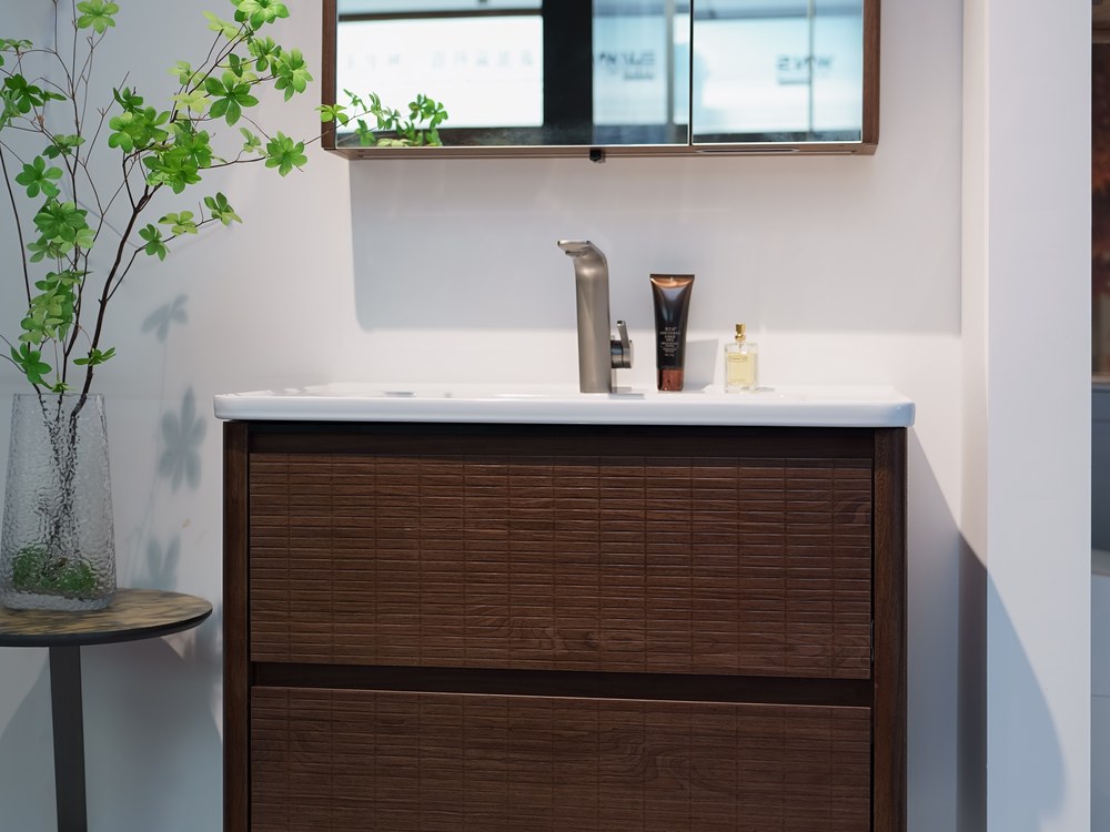 Walnut wall-mounted vanity with mirror cabinet on a WNS retail display