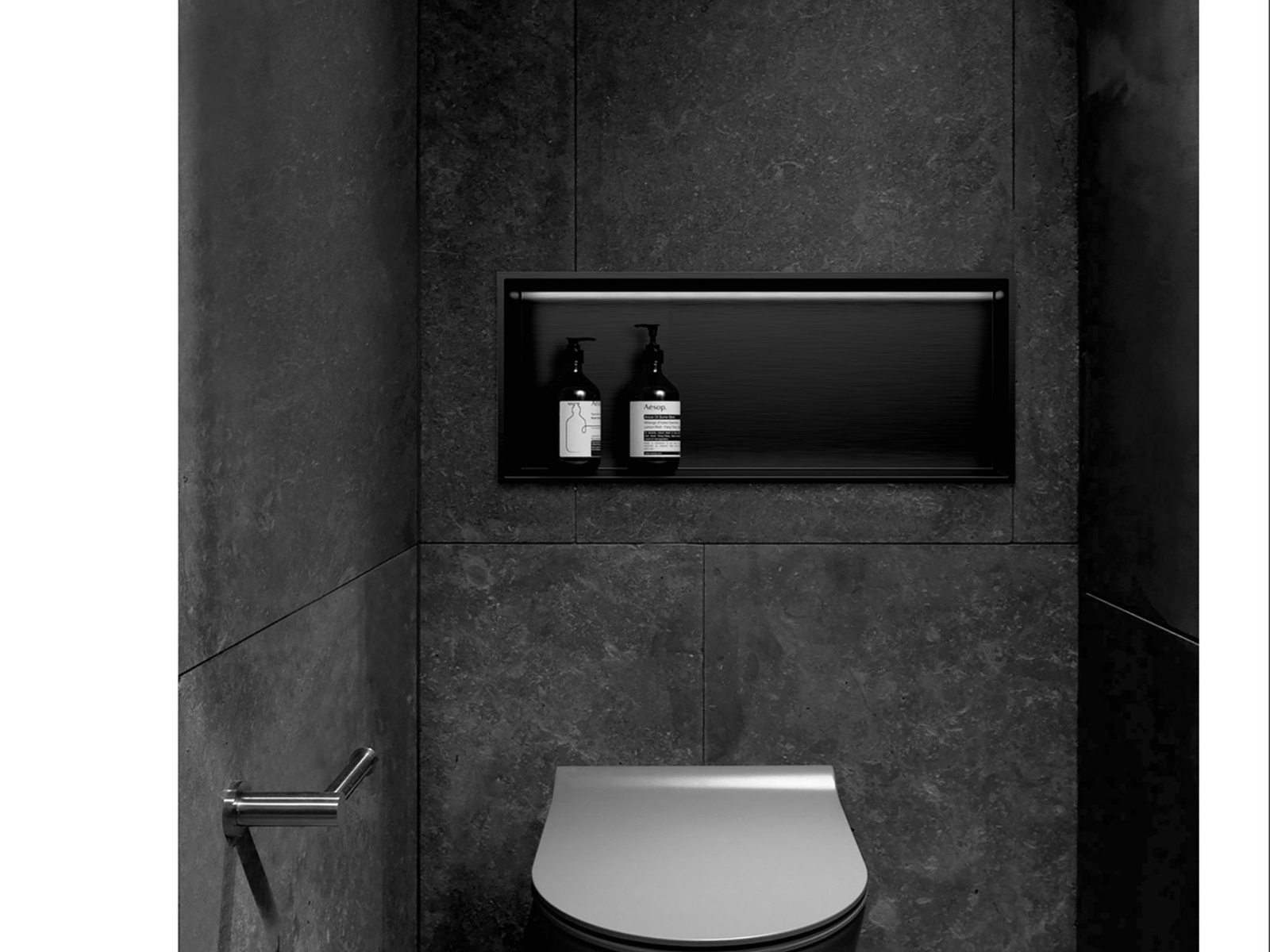 Recessed storage niche set into a dark tiled wall