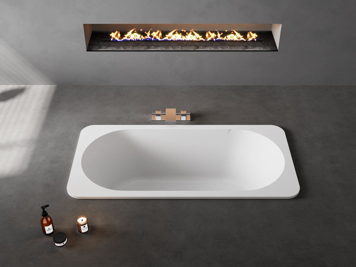Rectangular built-in solid surface tub in a stone deck under a window