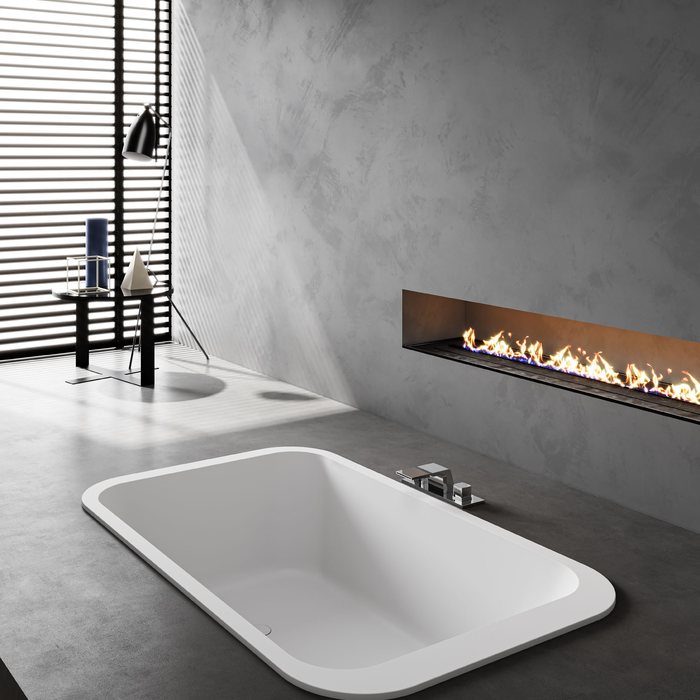 Rectangular built-in solid surface tub in a stone deck under a window