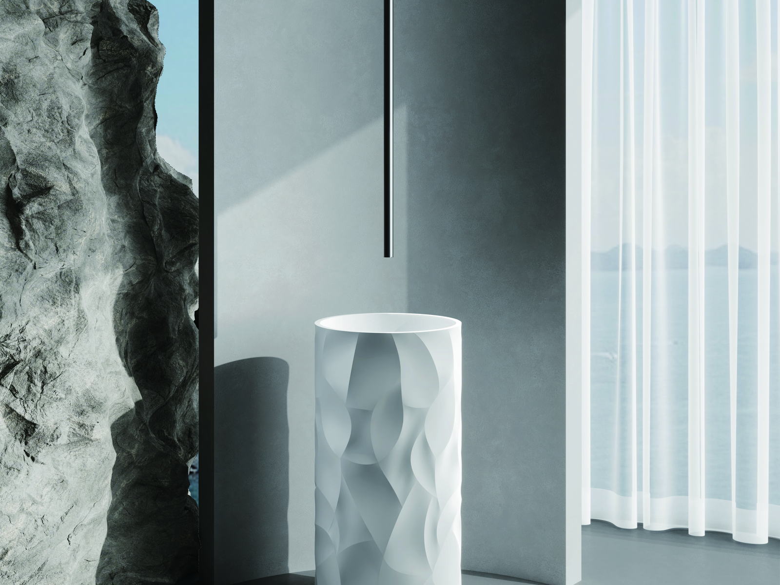 A textured white freestanding basin against a stone backdrop