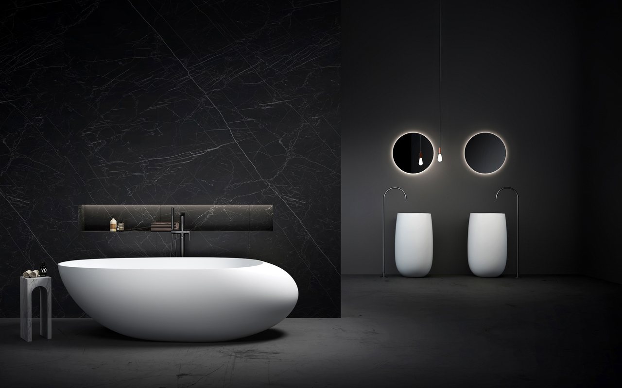 A white freestanding tub in a dark bathroom with two round mirrors