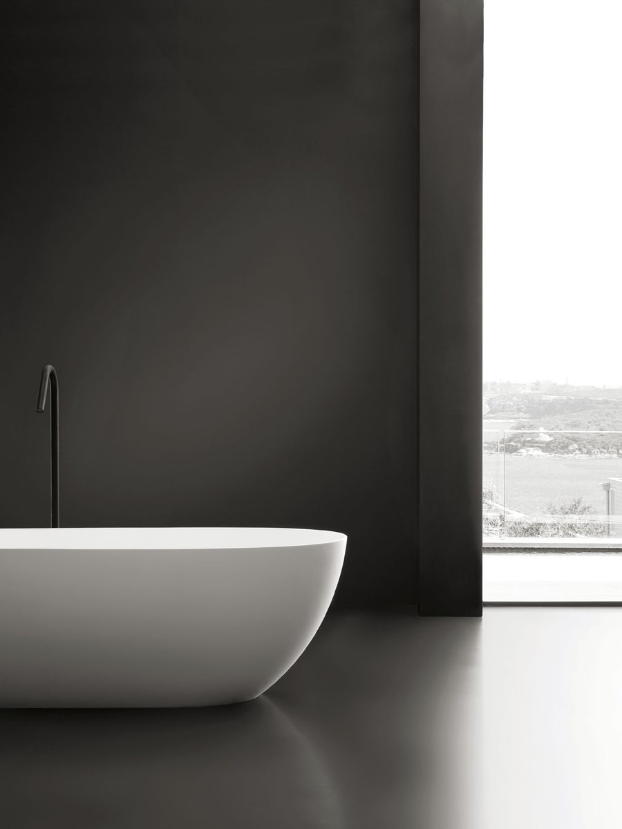 Compact upright soaking tub with floor-standing filler and stool