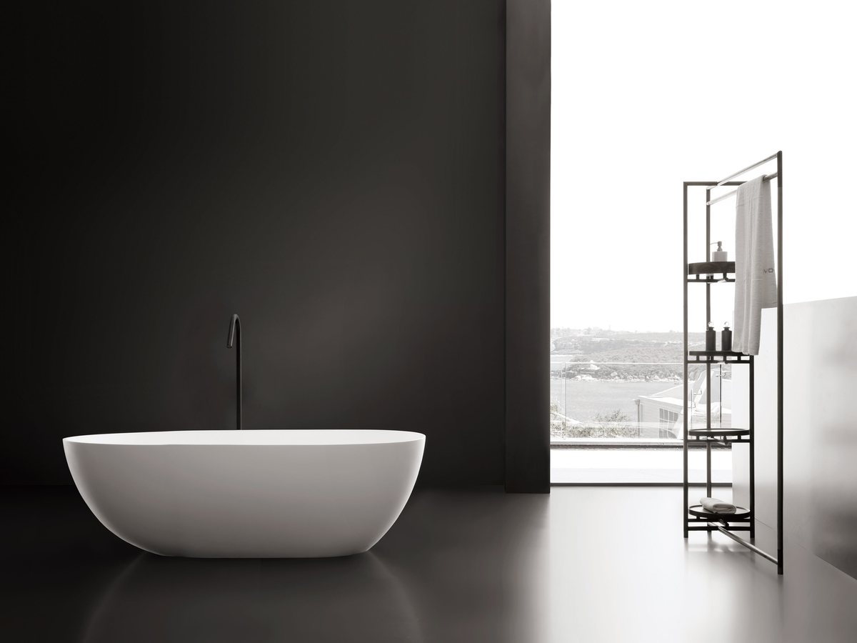 Compact upright soaking tub with floor-standing filler and stool