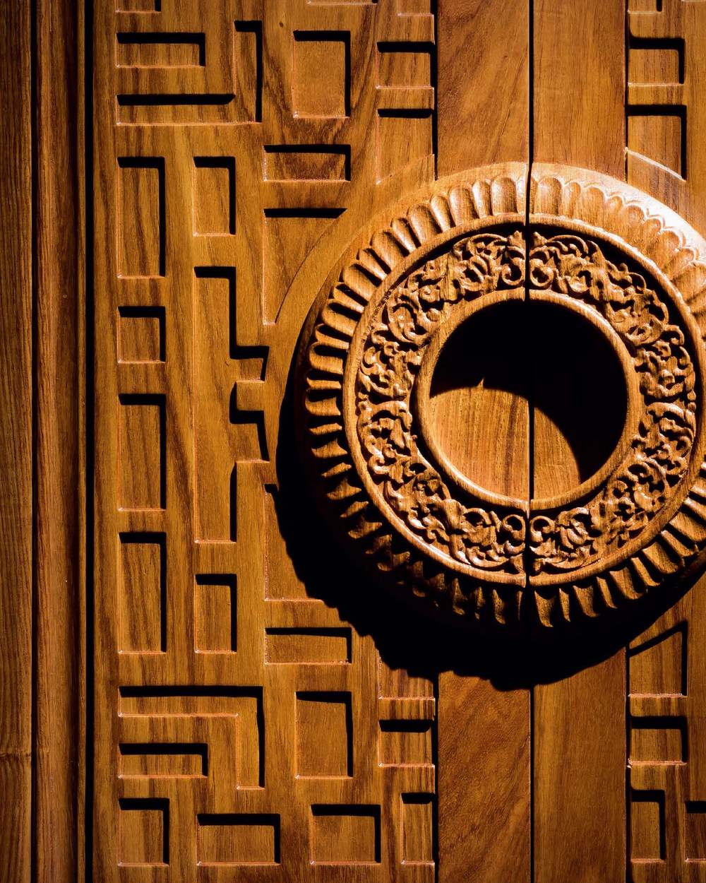 A carved solid wood panel with a circular relief detail