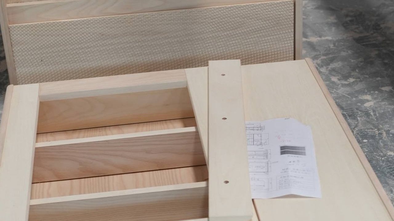 Cabinet body on the workshop floor with its production drawing laid on top
